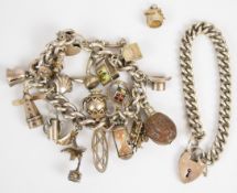 A silver charm bracelet with eighteen charms including a nut, propelling pencil, 'gamblers