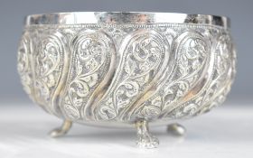 Indian, Burmese or similar silver bowl with lobed embossed decoration, raised on three feet,