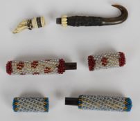 Three 19thC needle cases comprising a carved horn and bone parasol with dog finial and two