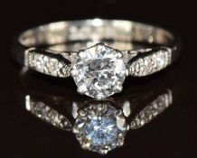A c1930 18ct white gold ring set with a diamond of approximately 0.58ct and two diamonds to each