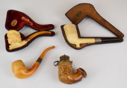 Four Meerschaum pipes comprising figural example with 9ct gold mount and Baltic amber mouthpiece,