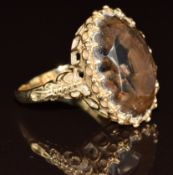 A 9ct gold ring set with an oval cut smoky quartz, 8.7g, size L