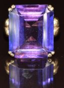A 9ct gold ring set with an emerald cut synthetic purple sapphire, 10.2g, size H