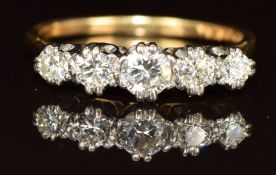 An 18ct gold ring set with five diamonds, the centre diamond approximately 0.25ct, 2.1g, size L