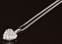 An 18k white gold pendant in the form of a heart set with diamonds (1.1 x 1.8cm) on an 18ct gold