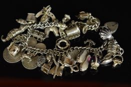 A silver charm bracelet with twenty silver charms including seahorse, dog, Concorde, etc ,129g