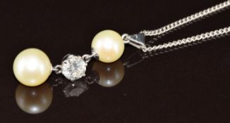 An 18ct white gold pendant set with a round cut diamond of approximately 0.8ct and two cultured