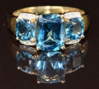A 9k gold ring set with three topaz and diamonds, 4.2g, size T