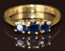 An 18ct gold ring set with three round cut sapphires, 3.3g, size N
