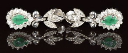 A pair of 14k white gold earrings each set with a pear cut emerald of approximately 0.35ct each