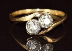 An 18ct gold ring set with two old cut diamonds, each approximately 0.3ct, in a twist setting, 2.1g,