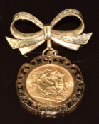 A 1914 gold half sovereign set into a 9ct gold bow brooch setting, 9.4g