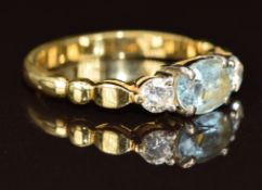 An 18ct gold ring set with an oval cut aquamarine and two round cut diamonds each approximately 0.