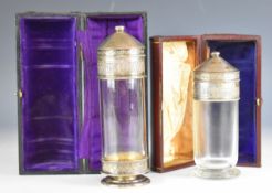 Two hallmarked silver and glass communion or similar sets, the glass bodies having a removable top