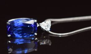 An 18k white gold pendant set with a cushion cut tanzanite of approximately 6.7ct and a trillion cut