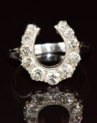 A c1920 18ct gold ring set with graduated diamonds in a horseshoe shaped platinum setting, 6.1g,