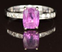 An 18ct white gold ring set with a pink sapphire of approximately 2ct and diamonds to the shoulders,