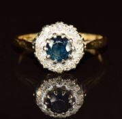 An 18ct gold ring set with a sapphire surrounded by diamonds, 3.1g, size M