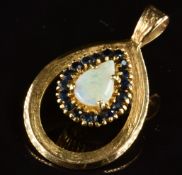 A 9ct and 18ct gold pendant set with a pear cut opal surrounded by sapphires, 7.3g, 3.5 x 2.2cm