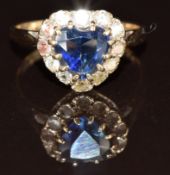 A 9ct gold ring set with a heart cut synthetic sapphire surrounded by paste stones, 2.5g, size L