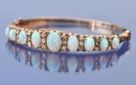 An 18ct gold Victorian bangle set with nine graduated oval opal cabochons (largest opal 1.2ct,