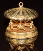 A 9ct gold charm/ pendant in the form of a carousel with spinning horses 12.9g, 2.5cm