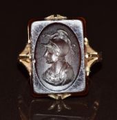 A c1920 9ct rose gold ring set with an agate intaglio depicting a warrior, 5.2g, size H