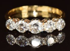 An 18ct gold ring set with five diamonds in a platinum setting, the centre diamond 0.3ct, 3.6g, size