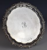South African silver salver with shaped edge, raised on three scroll feet, with South African silver
