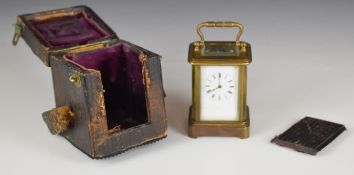 Brass miniature carriage clock with bevelled glass and white enamel dial, in original travel case,