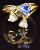An 18ct gold ring set with an trilliant cut tanzanite of approximately 0.4ct and two trilliant cut