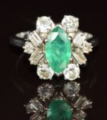 An 18ct white gold ring set with a marquise cut emerald of approximately 1ct surrounded by round and