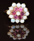 A 9ct gold ring set with opals and rubies in a cluster setting, 3.4g, size L