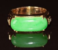 An 18k gold ring set with a jadeite cabochon and two diamonds to each shoulder, 9.5g, size R