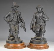 Pair of 19th / 20thC spelter figures of a puppeteer and musician with a monkey in his jacket, raised