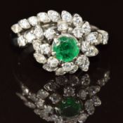 An 18k white gold ring set with an emerald of approximately 0.5ct surrounded by diamonds, 5.9g, size