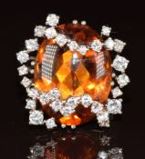 An 18k white gold ring set with a citrine cabochon and diamonds in an abstract setting, 11.5g,