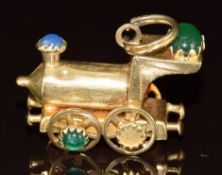 An 18ct gold charm in the form of a steam train locomotive set with cabochons, 9.2g, 3.0cm