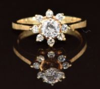 A 14k gold ring set with a round cut diamond of approximately 0.3ct, surrounded by further diamonds,