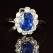 An 18ct white gold ring set with an oval cut sapphire of approximately 1ct surrounded by diamonds,
