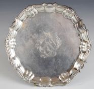 Georgian hallmarked silver card tray or small salver with shaped edge, raised on three hoof feet,