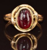 Victorian yellow metal ring in the form of two serpents set with a garnet cabochon, 4.8g, size T