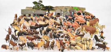 A collection of Britains or similar resin and plastic farm animals and buildings.