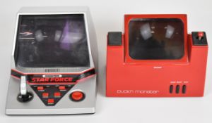 Two retro 3D LCD electronic game consoles comprising Grandstand Star Force and Rosy Puck'n Monster.