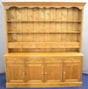 Pine dresser with an arrangement of nine drawers and four cupboards, W202 x D182 x H40cm