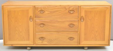 Ercol light elm mid century modern low sideboard with three drawers flanked by two cupboards, W155 x