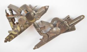 Two flintlock locks, possibly from a cannon or wall mounted gun, one with engraved decoration,