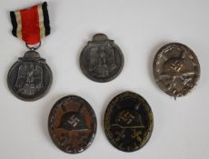 Three German WW2 wound badges together with two Eastern Front Medals
