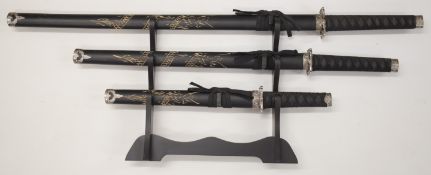 A set of three Japanese Samurai swords, all with bound handles and carved scabbards, largest 101cm