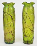 A pair of Kralik iridescent glass vases with trailed decoration over a green ground, 39cm tall.